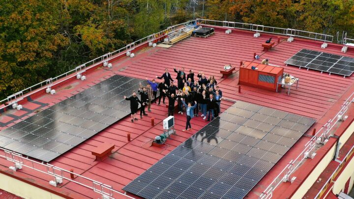 Bild på taket med solpaneler och människor